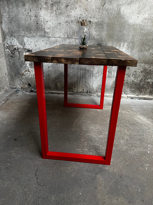 Wooden table supported by red rectangular steel legs