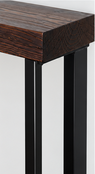 Close-up of black powder-coated asymmetric steel console table leg beneath a dark wooden top