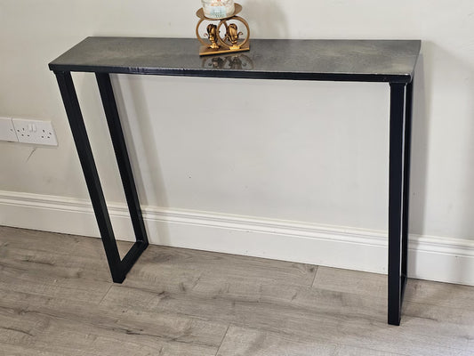 Front view of a dark console tabletop supported by black steel legs
