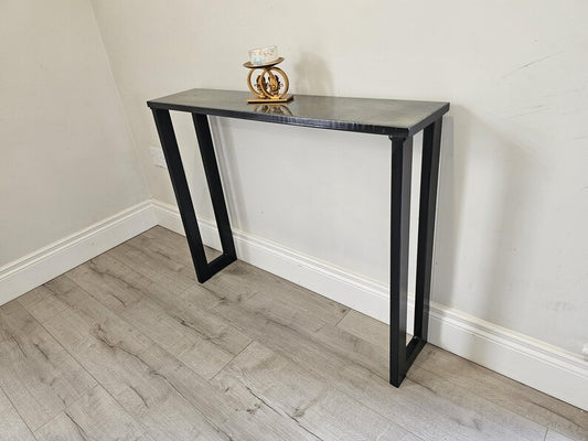 Wide view of a console table supported by black rectangular steel legs