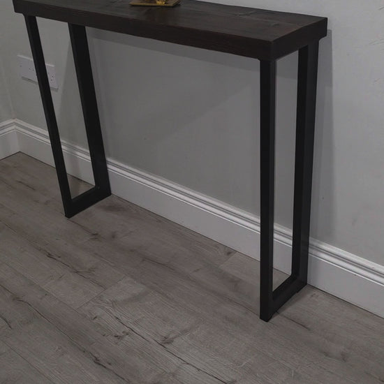 Video showing handmade asymmetric black powder-coated metal console table legs and their rectangular steel frame