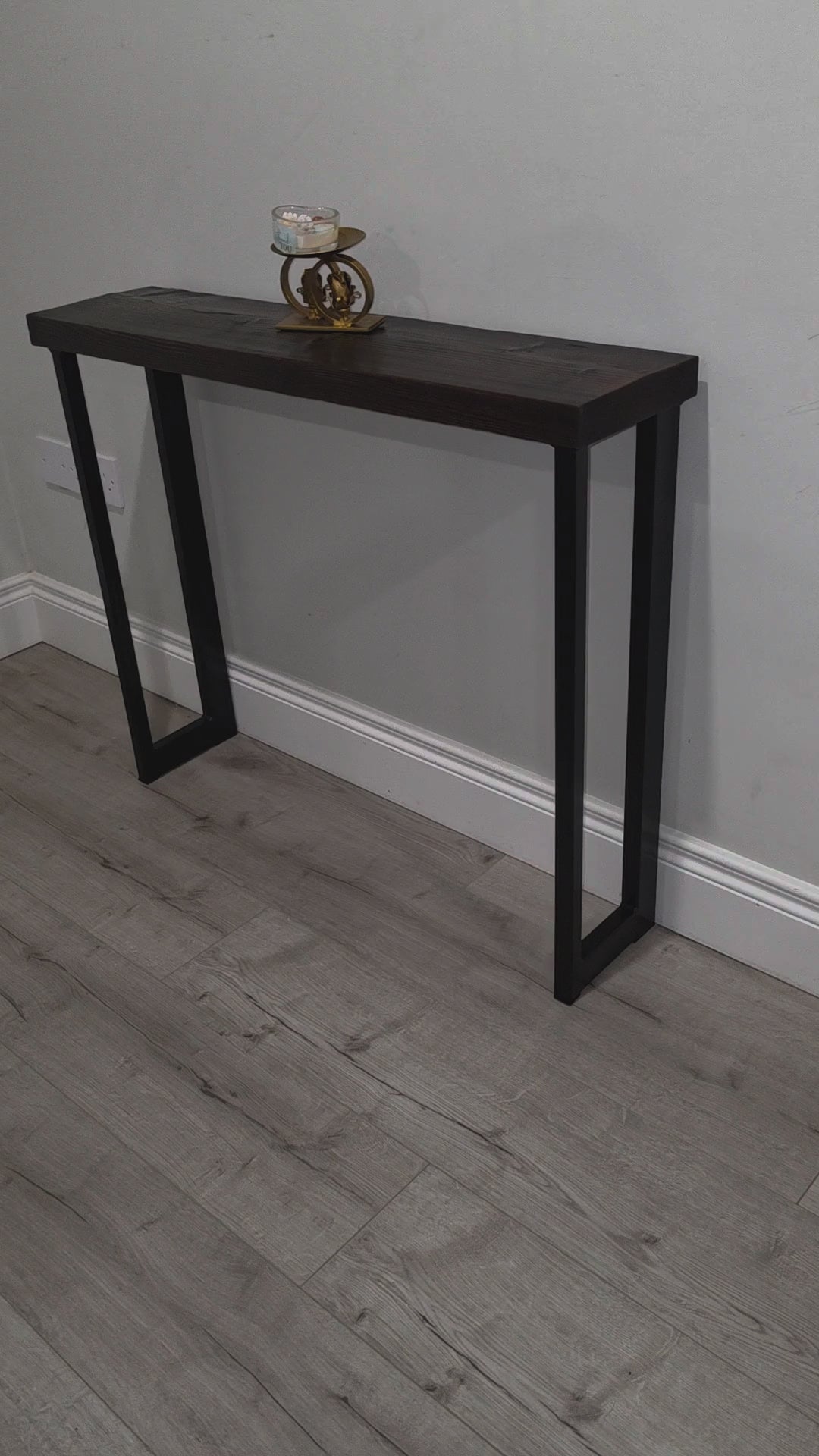 Video showing handmade asymmetric black powder-coated metal console table legs and their rectangular steel frame